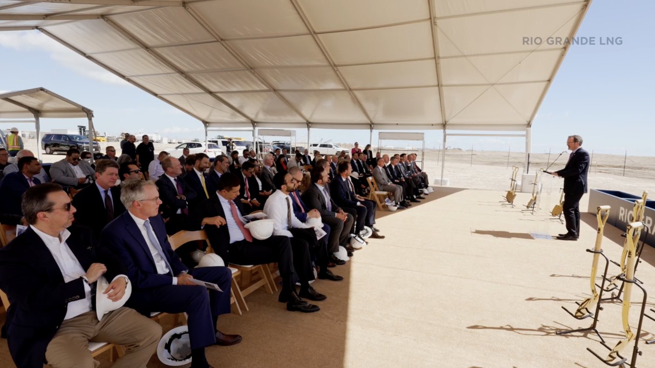 A seated audience under a tent watching the groundbreaking ceremony from the site