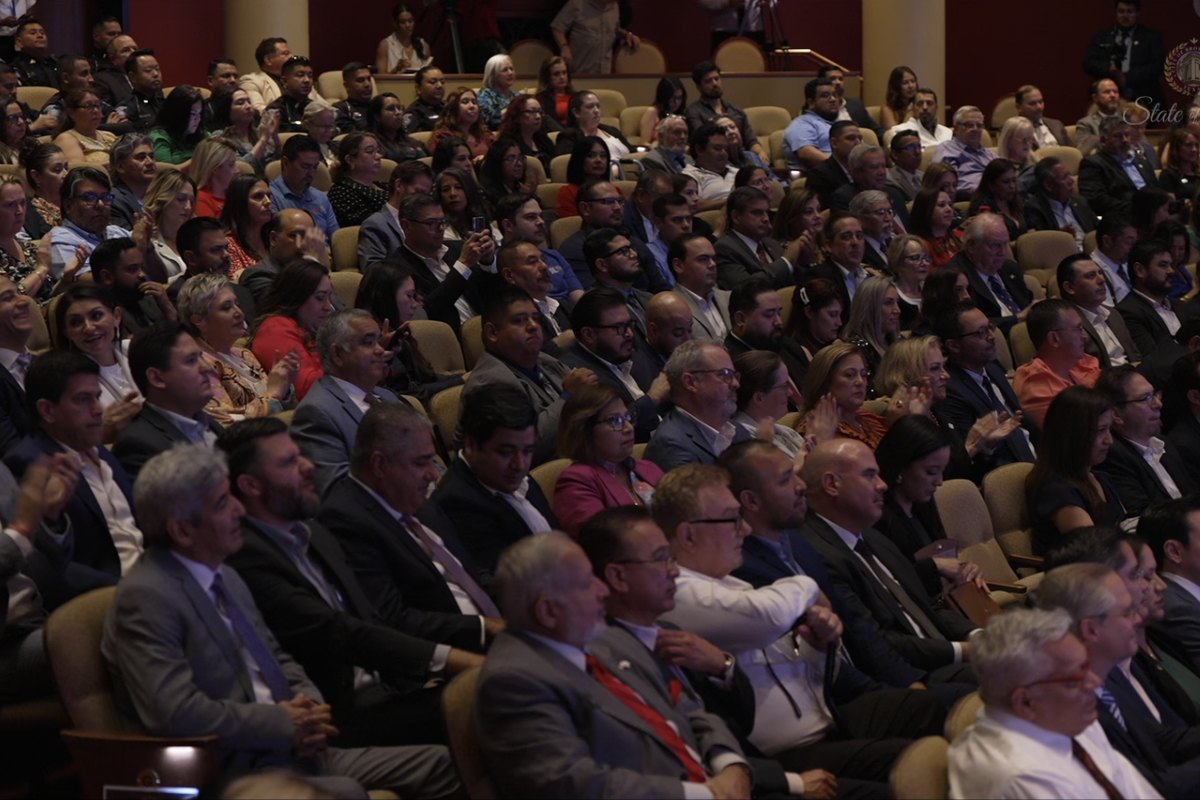 A packed theater audience applauding during a live broadcast