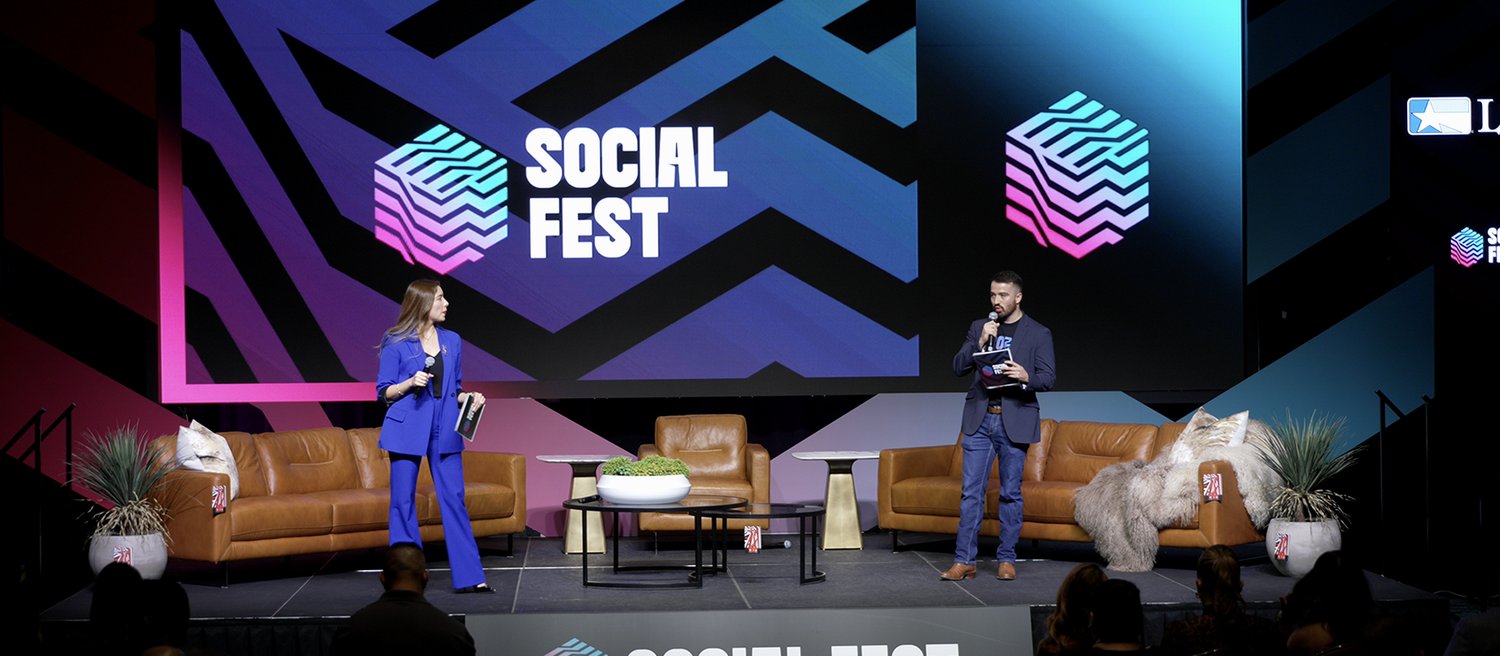 Hosts on a festival stage in McAllen in front of a full-width LED wall carrying the event's artwork